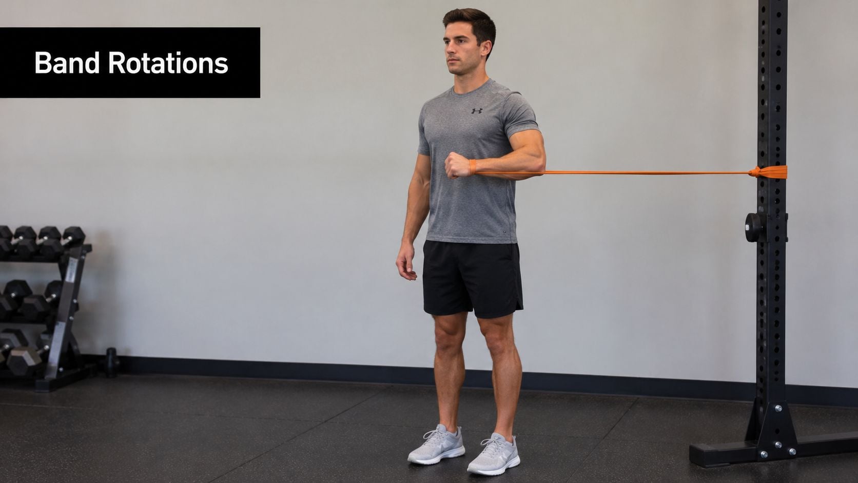 A man performing a shoulder resistance band internal rotation exercise in a gym setting.