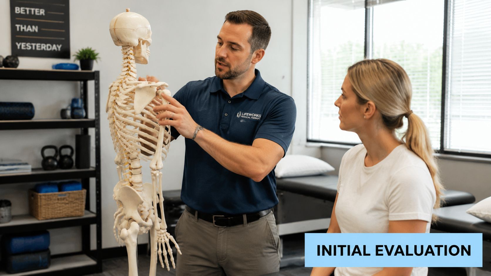 A physical therapist explains a shoulder injury to a patient using a skeletal model in his office.